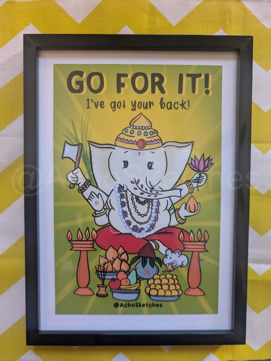 A framed Ganesha art print with the text 'GO FOR IT! I've goi your back!' featuring an illustration of Ganesha on a yellow background, enclosed in a black frame and set against a yellow and white chevron backdrop.